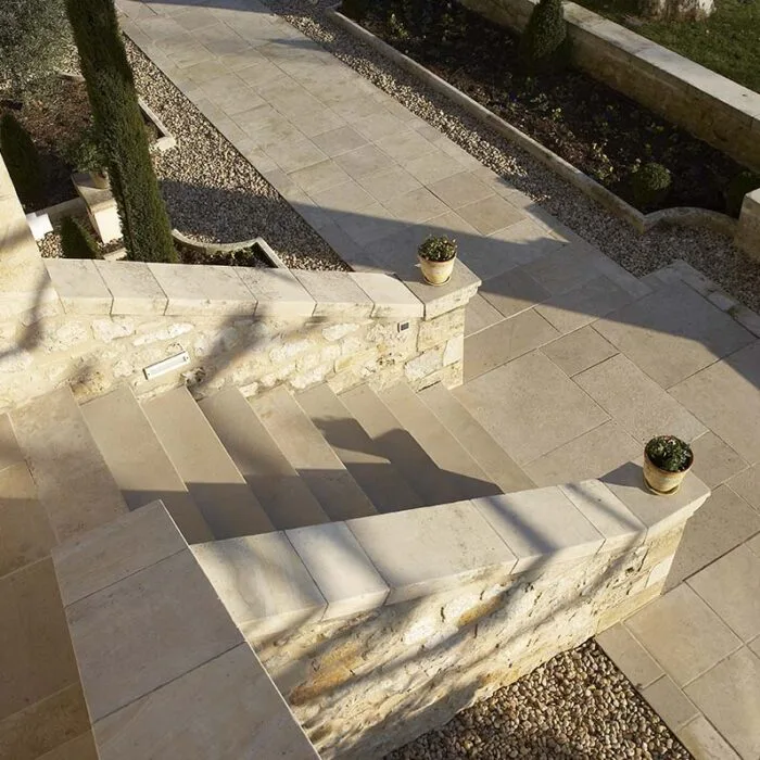 Escalier extérieur en pierre naturelle avec habillage complet de l’entrée d’une maison.