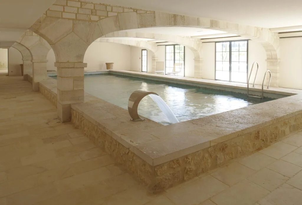 Piscine intérieure avec margelles et dallage en pierre calcaire naturelle