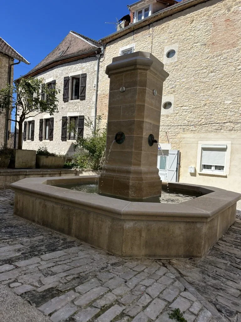 Fontaine historique de Souillac dans la rue piétonne rénovée en pierre naturelle